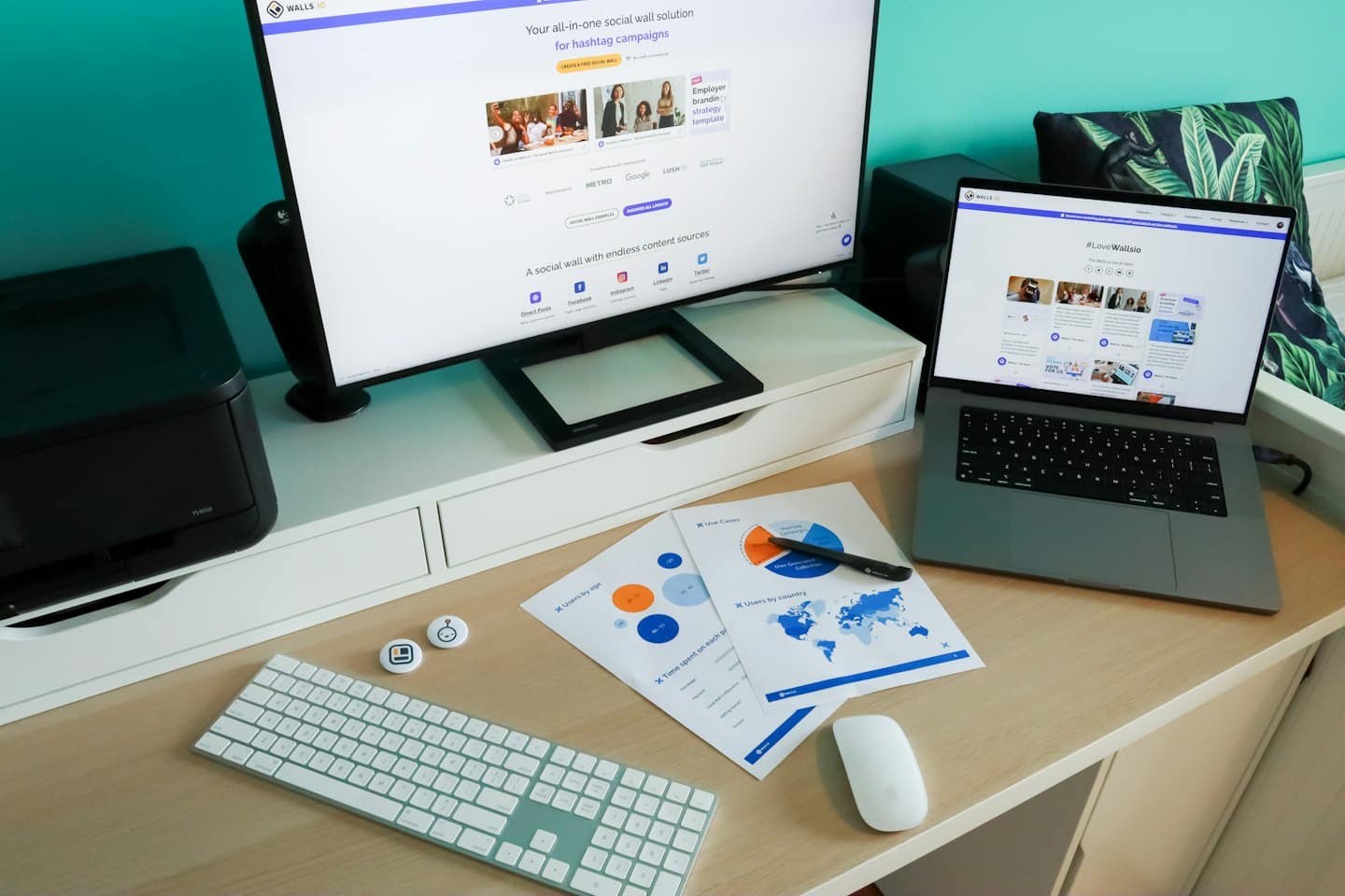 Escritorio de oficina en casa con monitores, informes y impresora.