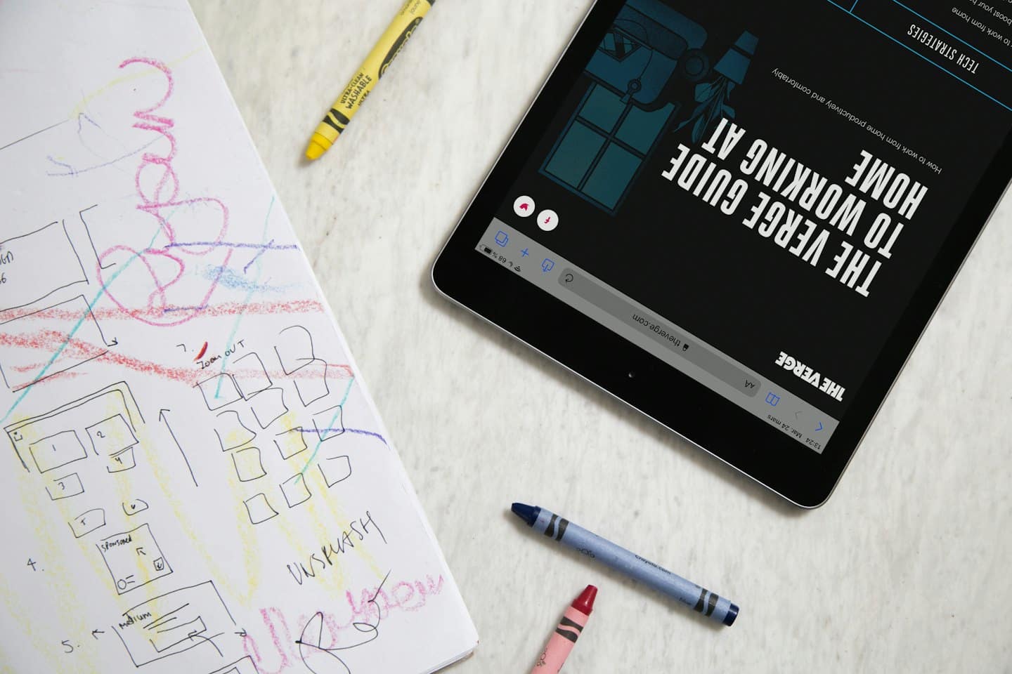 Una tableta y un cuaderno de bocetos de diseño sobre un escritorio.
