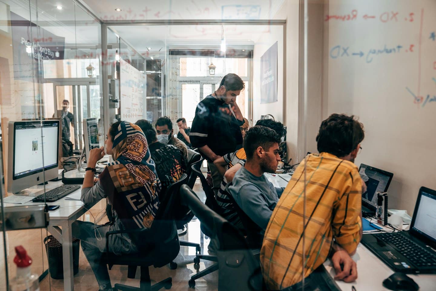 Profesionales colaboran en portátiles en una oficina luminosa y moderna.